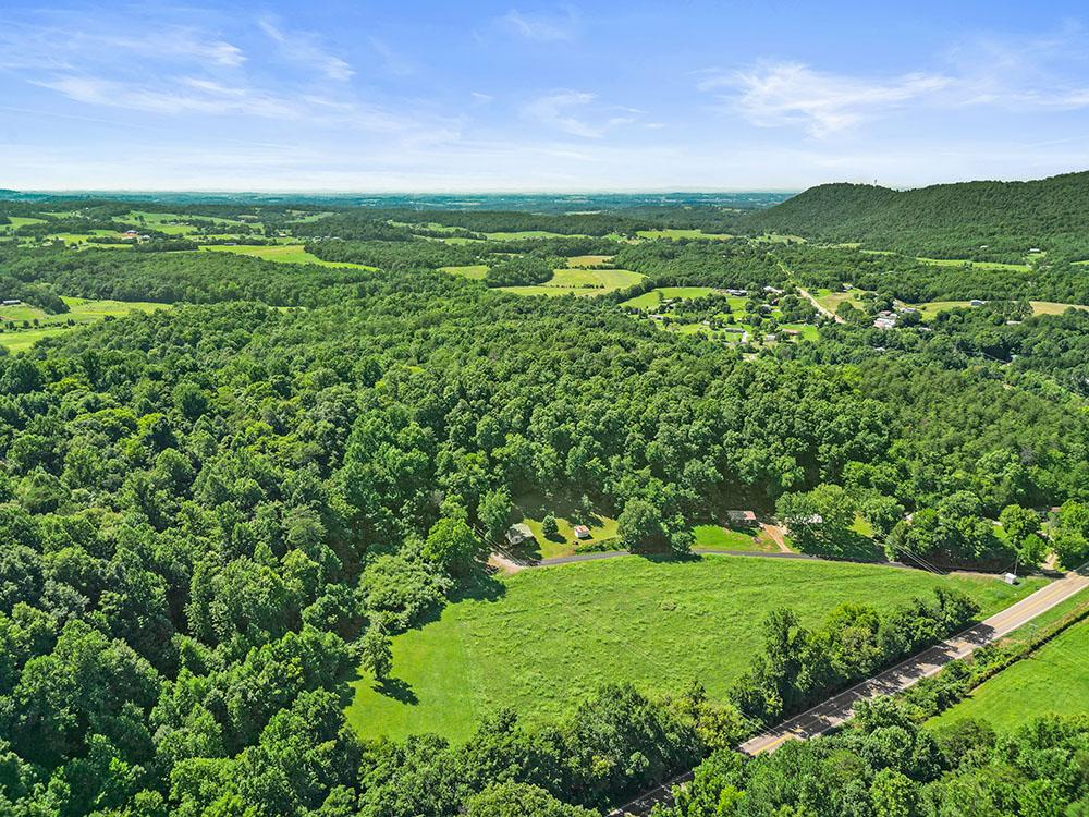 Aerial view of wooded ridges and open pasture in rural Greene County
